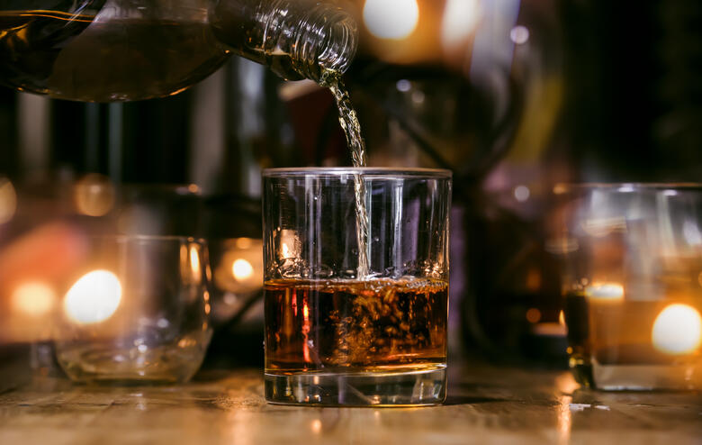 An einer Bar wird Whiskey in ein Glas gefüllt