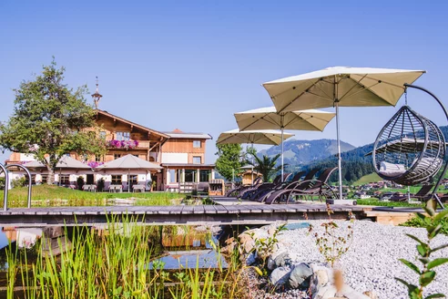 Außenansicht Hotel Sommer mit Schwimmteich im Vordergrund